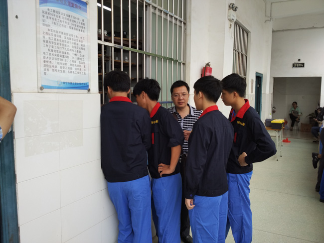 电气维修项目指导老师冯永章主任在赛前指导学生比赛注意要点.jpg
